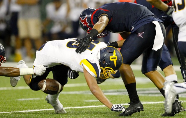 Punahou's Enoch Nawahine dropped a pass after being hit by Saint Louis' Isaiah Tufaga during Thursday night's game. The ILH clarified its format for determining a champion in the case of a regular-season first-place tie on Friday. Jamm Aquino / Honolulu Star-Advertiser.