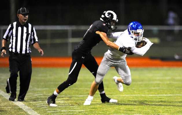 All 14 Oahu Interscholastic Association Division I teams are in the running for one of eight spots in the Open or D-I state tournaments. Four will go to each. Neither Moanalua nor Radford has been to a Division I state tournament, but the odds of them doing so this year have increased under the new three-tier state format. In photo, the Rams' Jonah Soakai tackled Na Menehune receiver Brandon Bender in Moanalua's 40-0 victory Friday. Bruce Asato / Honolulu Star-Advertiser.