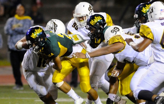 Mililani's Jalen Olomua and Joshua Banks stopped Leilehua's Kaleo Aloha Piceno. Photo by Bruce Asato/Star-Advertiser.