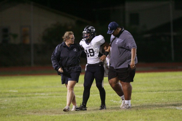 Kamehameha linebacker Trey Kodama walked off the field with the training staff during a 2010 game against Farrington. Cindy Ellen Russell/Star-Advertiser.