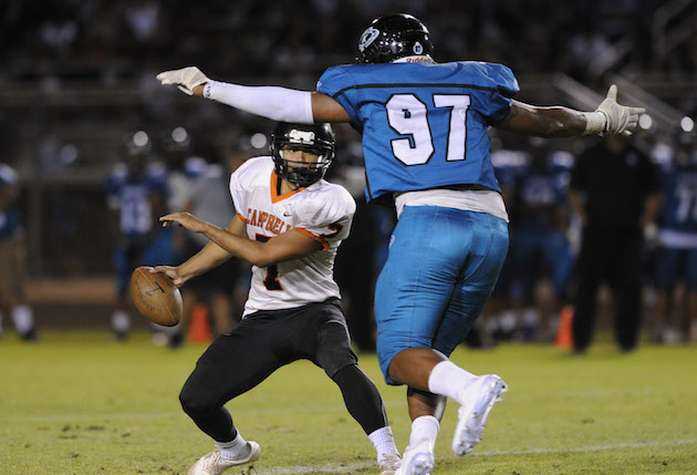 Campbell made the biggest move among Hawaii teams up the MaxPreps national rankings between Aug. 14 and Sept. 27. Kapolei also made a big move and is ranked No. 4 in the state and No. 480 in the nation. In photo, Campbell quarterback Kawika Ulufale tried to escape the rush of Kapolei's Myron Tagovailoa-Amosa in an Aug. 5 game. Bruce Asato / Honolulu Star-Advertiser.