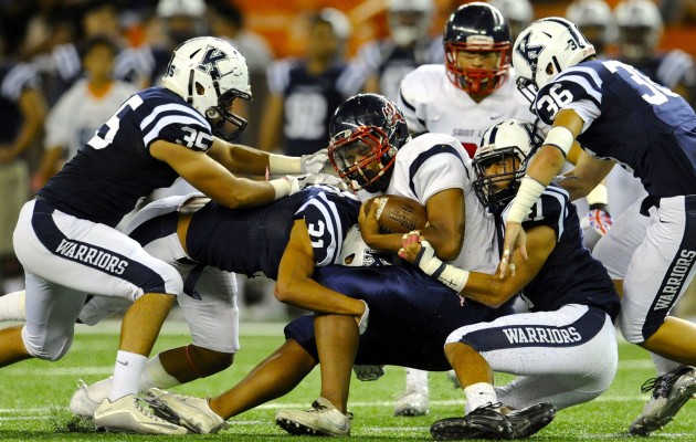 Saint Louis QB Tua Tagovailoa was stopped by Kamehameha's Tiger Peterson and Jacob Lealamanua after picking up a first down. Photo by Bruce Asato/Star-Advertiser.