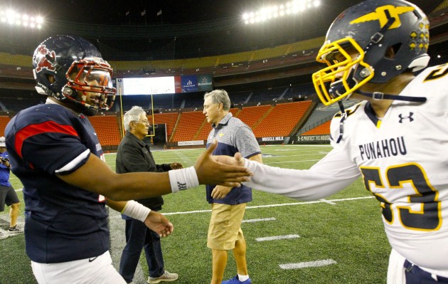 Saint Louis coach Cal Lee and Punahou coach Kale Ane shook hands as Crusaders quarterback Tua Tagovailoa and Buffanblu offensive lineman Blake Feigenspan shook hands in the foreground after a game on Oct. 21. Photo by Jamm Aquino/Star-Advertiser.