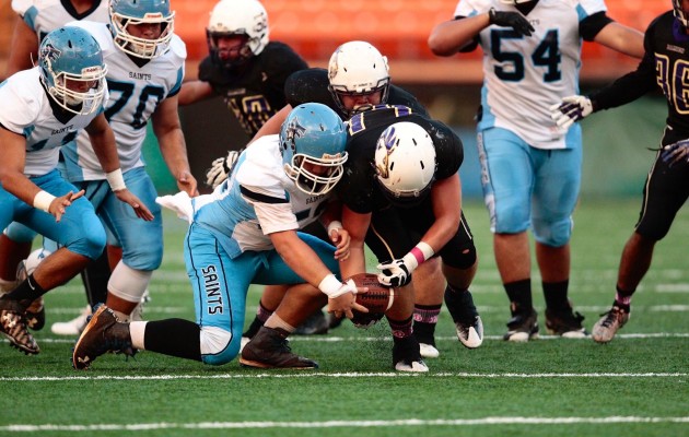 St. Francis RB Tyson Shimabukuro fumbled after a hit by Damien's Braxton Wilcox in the first quarter. Photo by Jamm Aquino/Star-Advertiser.