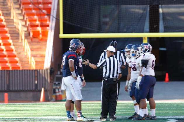 Captains for Saint Louis and Waianae meet at midfield. Photo by Jamm Aquino/Star-Advertiser.