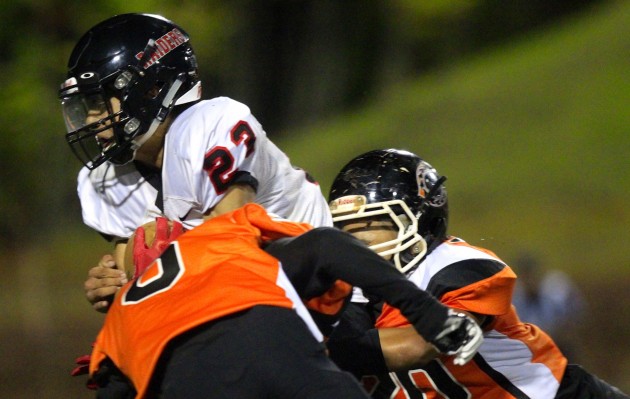 ‘Iolani's Justin Genovia tried to plow through two Campbell defenders after a catch during the Raiders' 35-12 win in the state Division I semifinals in Mililani on Friday night. Cindy Ellen Russell / Honolulu Star-Advertiser.
