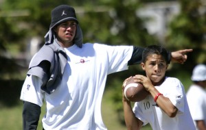 Former Saint Louis QB Timmy Chang watched Christian Akana during pass drills at a clinic at Kaiser in 2006. Star-Bulletin file photo.