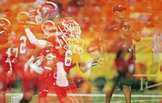 In this multiple exposure made in the camera, Kahuku quarterback Sol-Jay Maiava threw the football as head coach Vavae Tata watched prior to the Open Division semifinal against Kapolei. Photo by Jamm Aquino/Star-Advertiser.