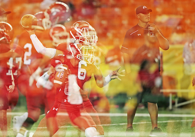 In this multiple exposure made in the camera, Kahuku quarterback Sol-Jay Maiava threw the football as head coach Vavae Tata watched prior to the Open Division semifinal against Kapolei. Photo by Jamm Aquino/Star-Advertiser.