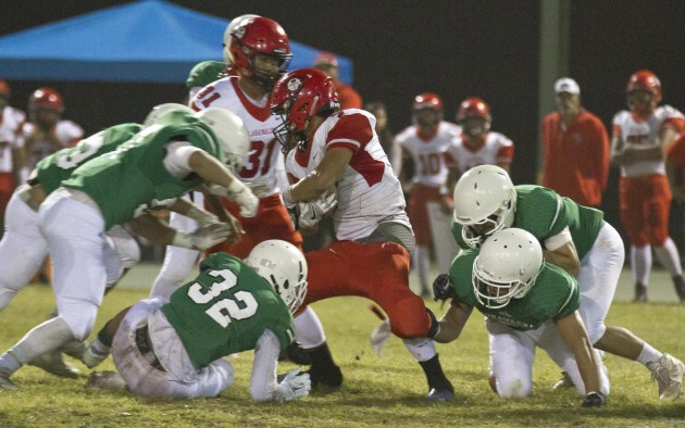 It takes several Konawaena defenders to bring down Lahainaluna running back Justice Tihada. (Photo courtesy of Rick Winters/West Hawaii Today)