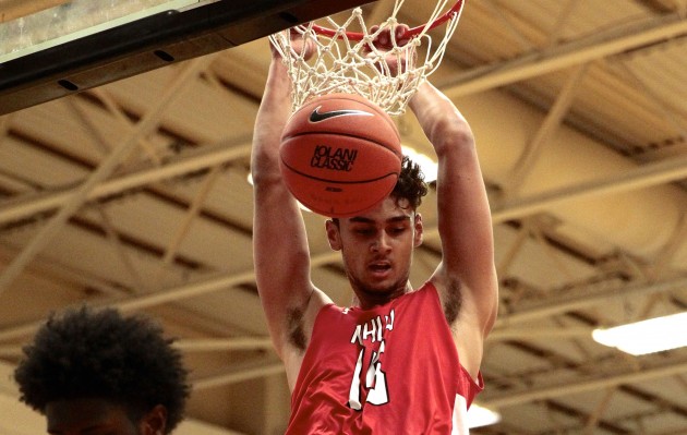 Kahuku forward Dan Fotu hanged on the rim after a slam dunk over Mount Vernon forward Derrick Hamlin during the second half at the ‘Iolani Prep Classic. The dunk tied the game and his ensuing free throw gave the Red Raiders a 55-54 lead en route a 60-54 upset win. Photo by Jamm Aquino/Star-Advertiser