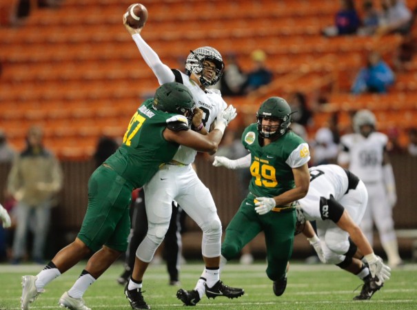 Kapolei's Myron Tagovailoa-Amosa put a hit on quarterback Alex Faniel in the first quarter of the Polynesian Bowl. Photo by Jamm Aquino/Star-Advertiser.