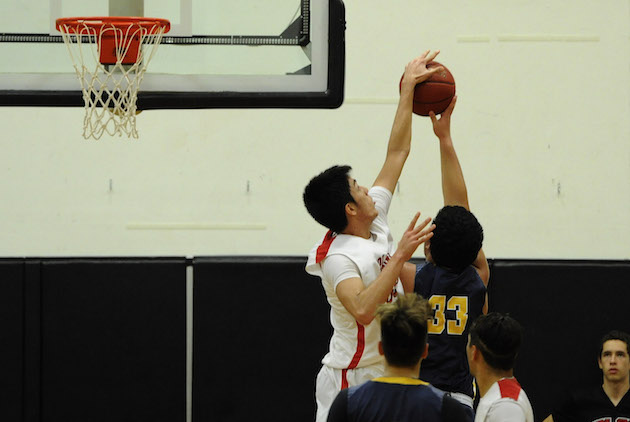 ‘Iolani’s Hugh Hogland blocked a shot attempt by Punahou’s Duke Clemens in the Raiders' 49-38 win on Wednesday night. Photo by Bruce Asato/Star-Advertiser. 
