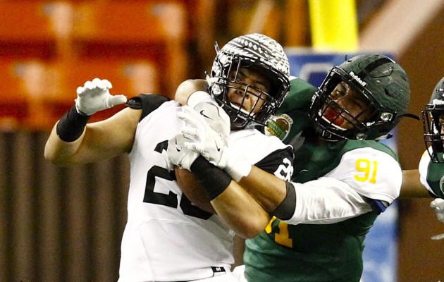 Kahuku defensive end Aliki Vimahi of Team Mariota worked to bring down Red Raiders teammate Kesi Ah-Hoy of Team Stanley during the Polynesian Bowl. Ah-Hoy later signed with Oregon State. He will be replaced by teammate Taimona Wright on the Public Schools roster of the  Geremy Robinson Senior Basketball Classic. Photo by Jamm Aquino/Star-Advertiser.