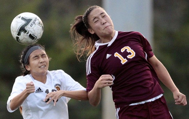 Mililani halfback Ki'i Aweau headed the ball away from Castle forward Kelsey Kano during the OIA playoffs. Photo by Jamm Aquino/Star-Advertiser.
