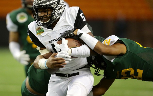 Sumner running back Connor Wedington, named offensive MVP, cut between Kahuku linebacker Sioeli Naupoto and and Saint Louis safety Jalen Saole. Photo by Jamm Aquino/Star-Advertiser.