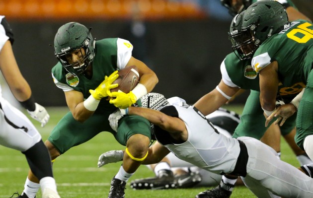 Farrington running back Challen Faamatau was brought down by Servite cornerback Keith Taylor. Photo by Jamm Aquino/Star-Advertiser.