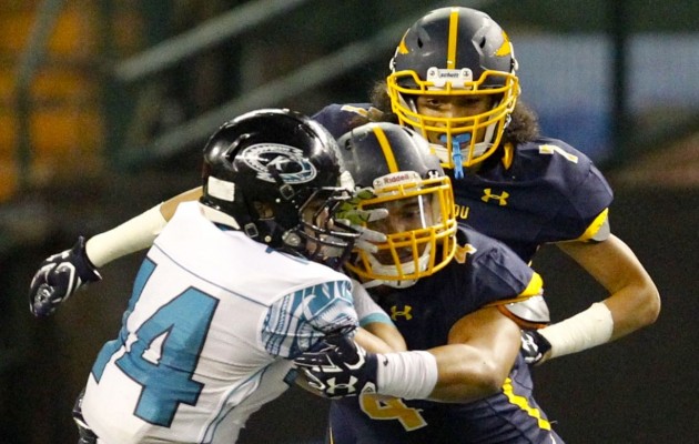 Punahou linebacker Seyddrick Lakalaka tackled Kapolei receiver Jaymin Sarono as Marist Liufau looked on in the first round of the Open Division state tournament. Photo by Jamm Aquino/Star-Advertiser.