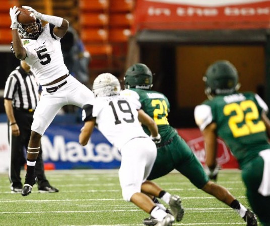 Running back Connor Wedington went high to make the catch in the third quarter for Team Stanley. Photo by Jamm Aquino/Star-Advertiser.