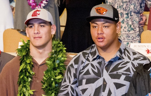 Waianae's Onesimus Lutu-Clarke, right, showed off his Oregon State hat at Wednesday morning's signing event. Next to him is Kailua's Christian Mejia. Photo by Craig T. Kojima/Star-Advertiser.