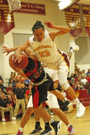 'Iolani's Justin Genovia was fouled hard by Maryknoll's Kainoa Ferreira in the second half of a physical game at the Spartans' gym on Monday. Photo by Jamm Aquino/Star-Advertiser.