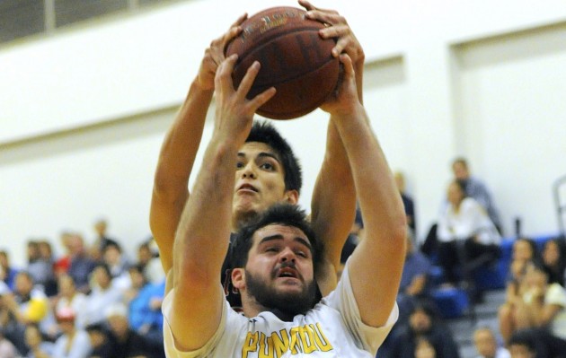 Punahou’s David Beau Whittaker battled Iolani’s Hugh Hogland to secure a rebound. Both teams are in the semifinals of the state tournament. Photo by Bruce Asato/Star-Advertiser.