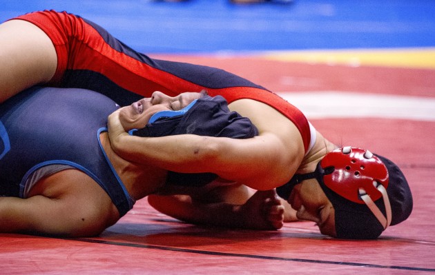 Teniya Alo, top, is going for her second wrestling state championship Saturday, and she has her sister, four-time individual champion Teshya Alo, as part of her support system at the Blaisdell Arena. Photo by Craig T. Kojima/Star-Advertiser.