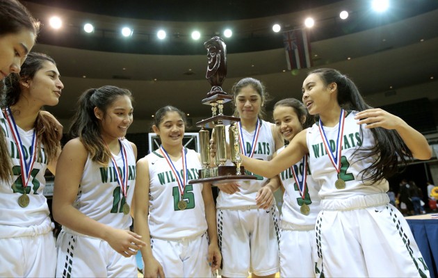 Konawaena guard Mikayla Tablit (2) handed the trophy to her teammates after Konawaena won its eighth state championship. Photo by Jamm Aquino/Star-Advertiser.