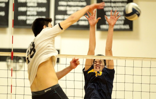 Punahou setter Buddy Scott went up to block Iolani's Hugh Hogland during the second set of a boys ILH volleyball game on Tuesday. Photo by Jamm Aquino/Star-Advertiser